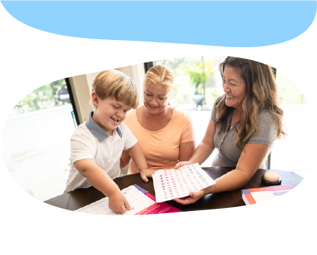 A child and two adults looking at a sheet of paper and smiling