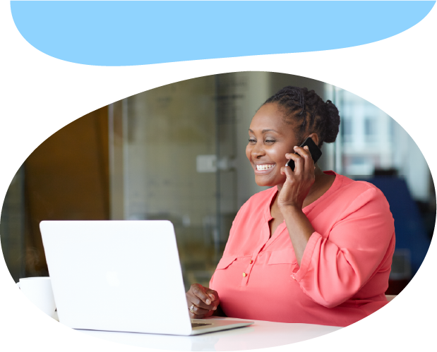 Adult talking on the phone and looking at a laptop