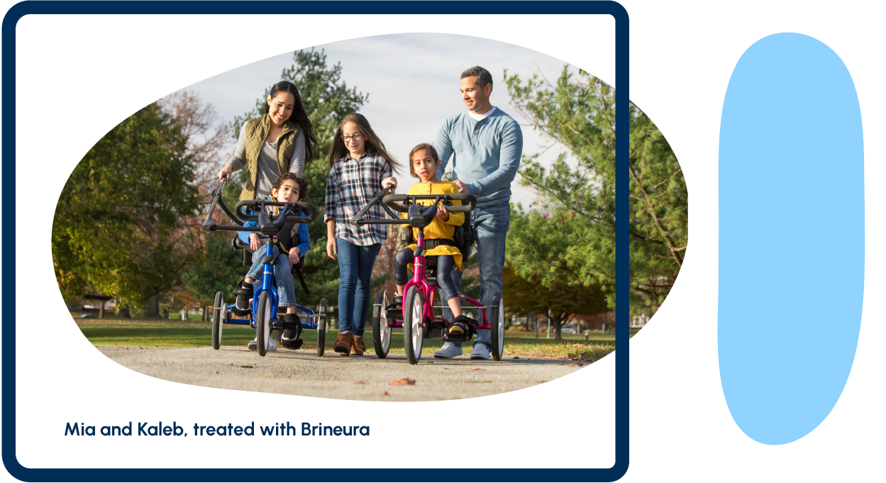 A family of five walking together and supporting two children on adaptive tricycles