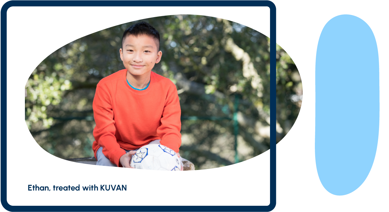 A teenager smiling and holding a soccer ball