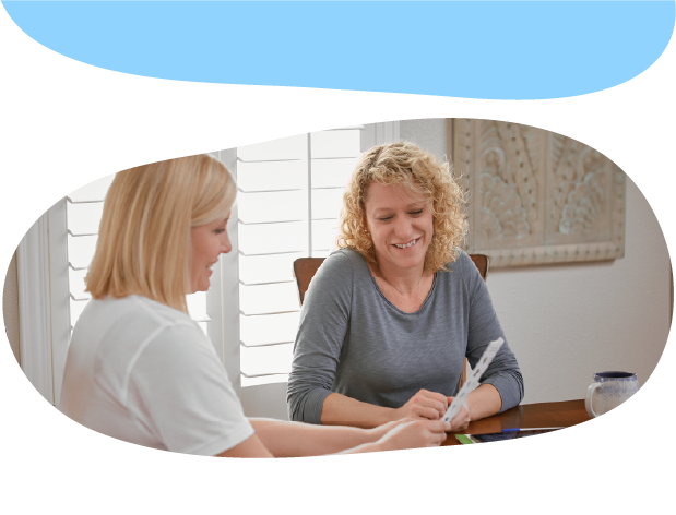 A doctor and an adult talking and looking at a sheet of paper