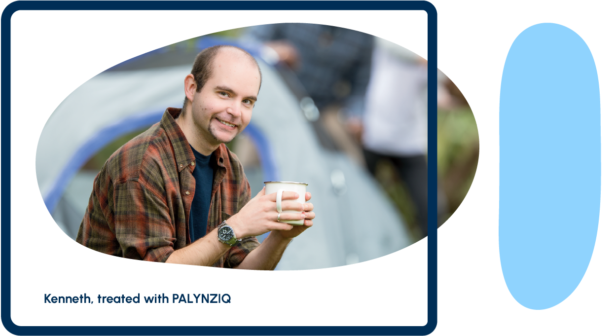 An adult person smiling and holding a cup of coffee
