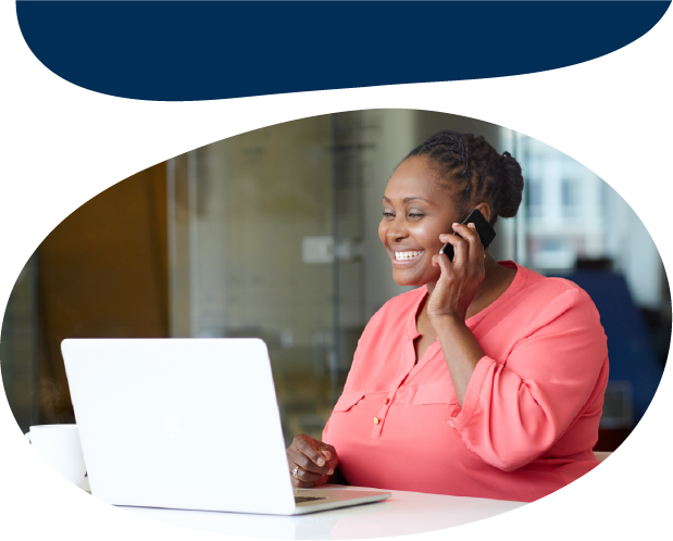 Adult talking on the phone and looking at a laptop