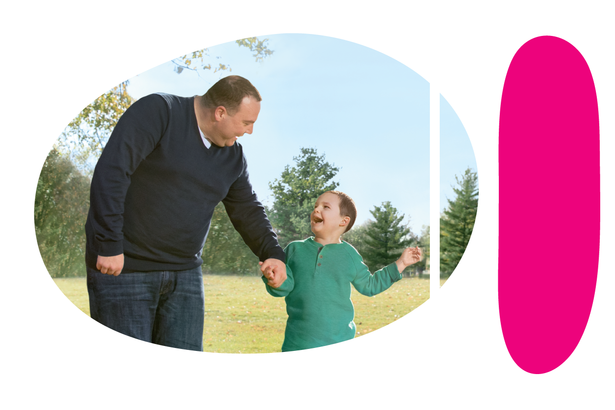 Adult smiling and holding the hand of a smiling child